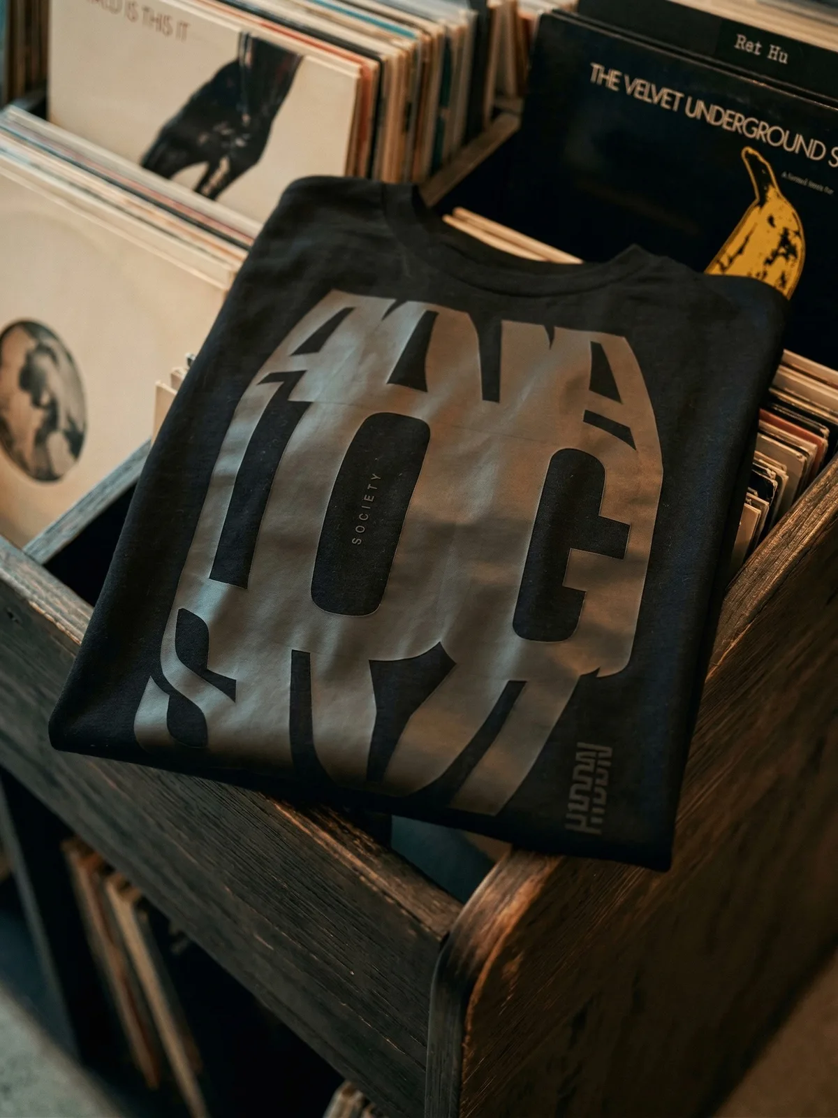 Analogism T-shirt folded in a wooden record crate